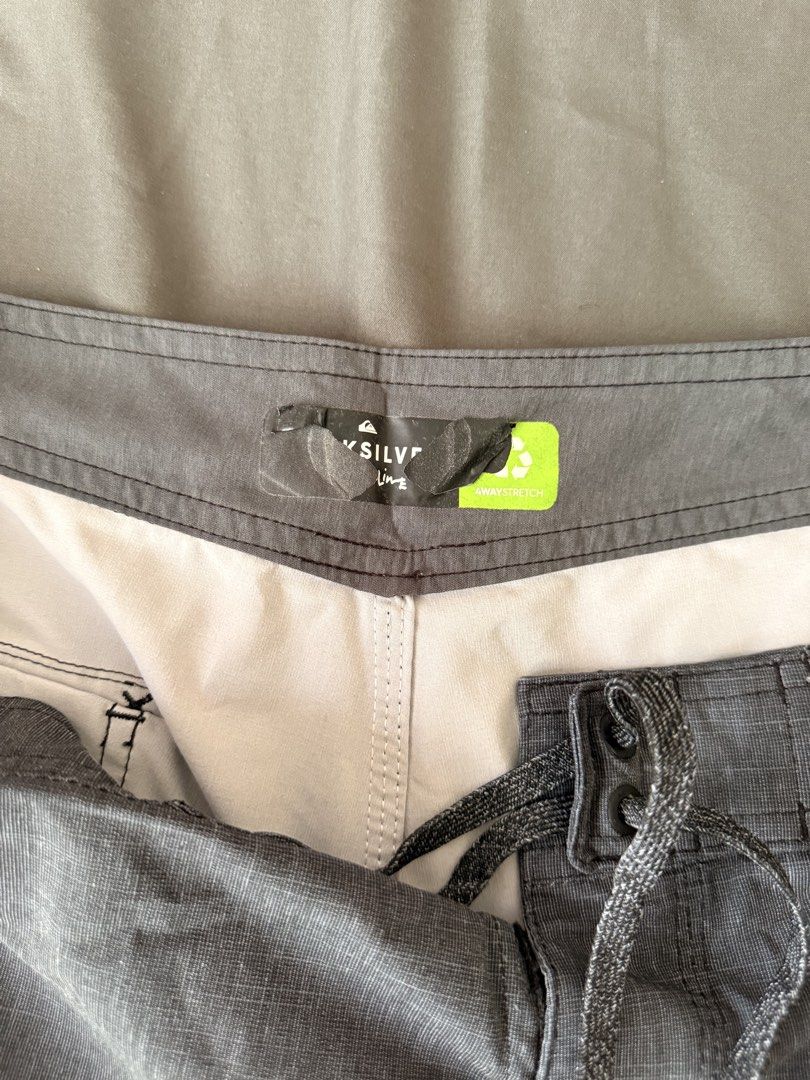 Quiksilver Board Shorts - Size 34 (Category: Swim Trunks & Board Shorts) located in Quezon City. Submitted by wringwraith (Listing ID 1439825241, Image 3). Description: Quiksilver board shorts in size 34. Features a gray base with a horizontal stripe design in red, orange, and yellow. Includes a back pocket and a drawstring closure. The shorts have a Quiksilver logo patch. Made with 4-way stretch material. Condition: 8/10 Size 34 on tag Issues: F