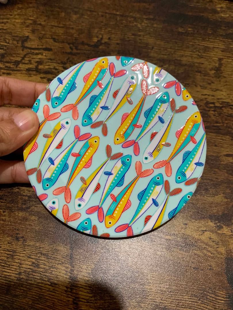 Solo Round Ceramic Coaster with Colorful Fish Design (Category: Other Kitchenware & Tableware) located in Bacolod City. Submitted by kyaramatcha (Listing ID 1439919158, Image 1). Description: - Round coaster with vibrant fish pattern - Colors: Blue, yellow, red, orange fish on light blue background - Protects surfaces from drinks - Adds a touch of whimsy to your home decor .