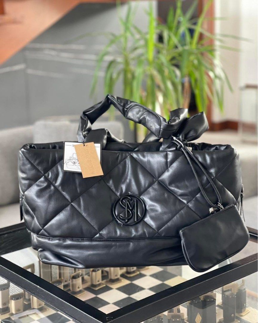 Steve Madden Quilted Tote Bag with Pouch (Category: Tote Bags) located in Caloocan City. Submitted by Roowchelly (Listing ID 1439968767, Image 1). Description: - Stylish black quilted tote bag by Steve Madden. - Features prominent SM logo. - Includes a convenient attached pouch. - Top handles have a chic ruched effect. - Versatile for everyday use or evening outings..