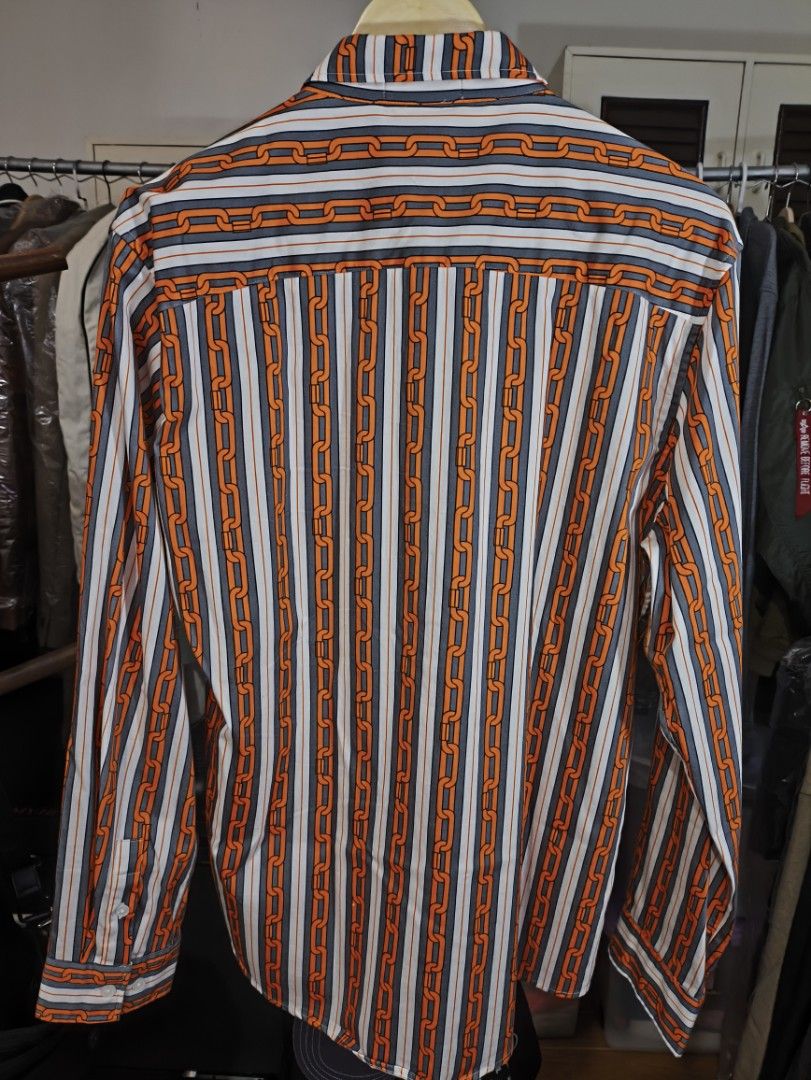 Striped Chain Print Long Sleeve Shirt (Category: Tshirts & Polo Shirts ) located in Cavite. Submitted by absolutepeak999 (Listing ID 1439834557, Image 2). Description: Long-sleeved silk shirt - Unique chain print design - Classic collar - Button-down closure - Striking orange chain pattern on striped background (white, grey, orange) - No issues, never worn - Plus Sf - No reservations; 1st to pay Dimensions: Pit to pit: 22" Length: 30" Shoulders: 