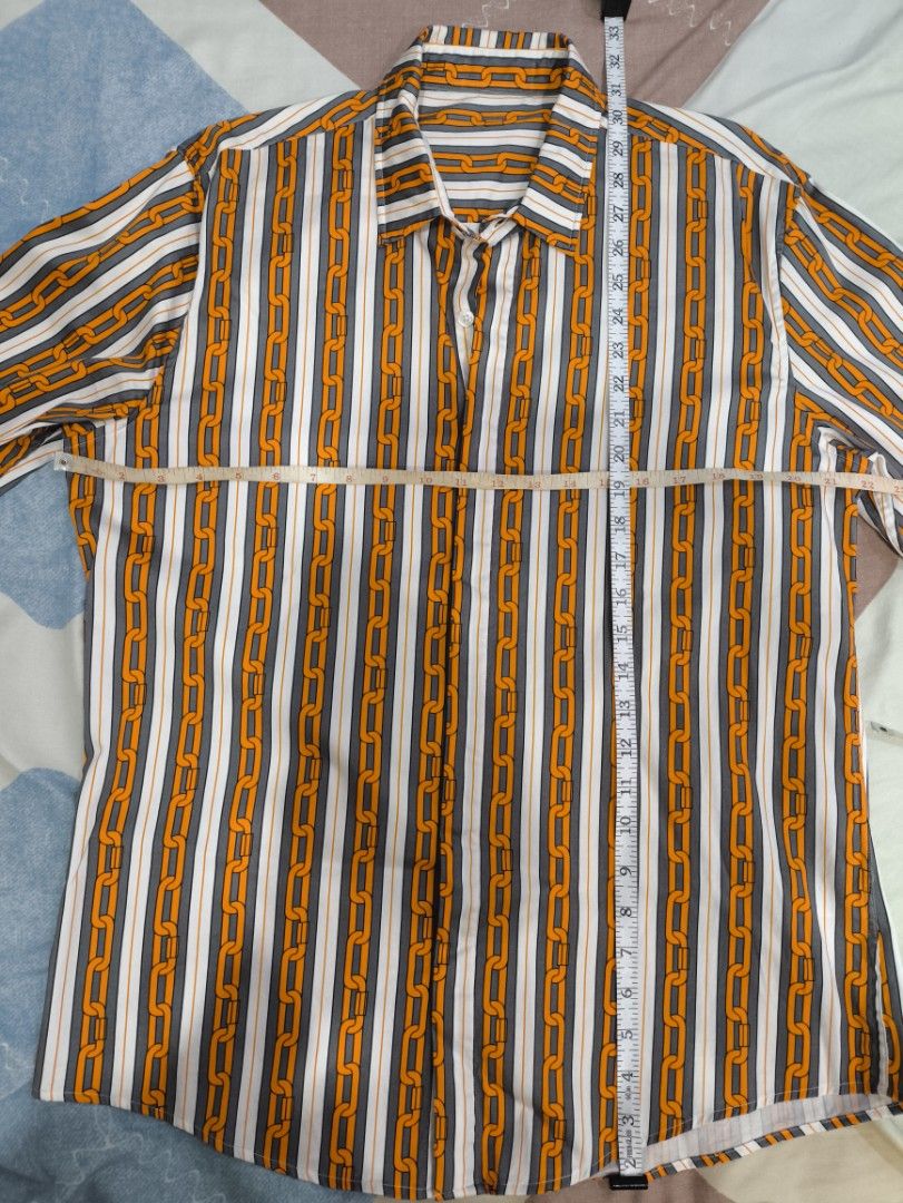 Striped Chain Print Long Sleeve Shirt (Category: Tshirts & Polo Shirts ) located in Cavite. Submitted by absolutepeak999 (Listing ID 1439834557, Image 3). Description: Long-sleeved silk shirt - Unique chain print design - Classic collar - Button-down closure - Striking orange chain pattern on striped background (white, grey, orange) - No issues, never worn - Plus Sf - No reservations; 1st to pay Dimensions: Pit to pit: 22" Length: 30" Shoulders: 
