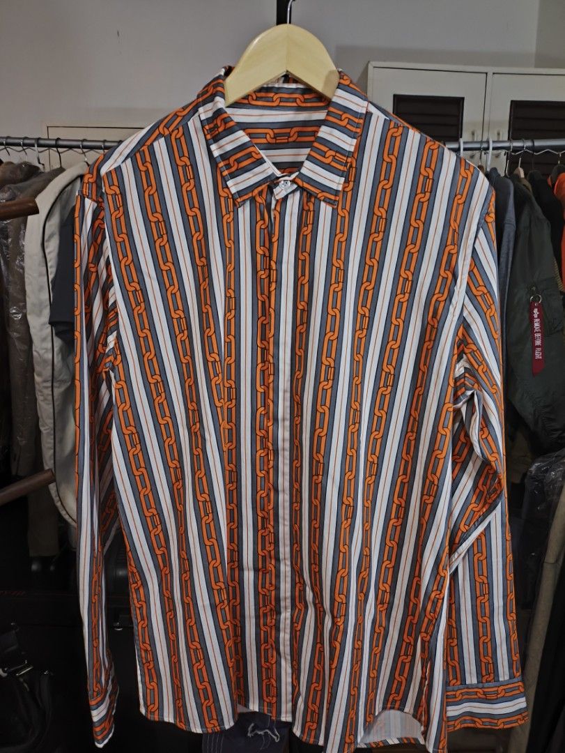 Striped Chain Print Long Sleeve Shirt (Category: Tshirts & Polo Shirts ) located in Cavite. Submitted by absolutepeak999 (Listing ID 1439834557, Image 1). Description: Long-sleeved silk shirt - Unique chain print design - Classic collar - Button-down closure - Striking orange chain pattern on striped background (white, grey, orange) - No issues, never worn - Plus Sf - No reservations; 1st to pay Dimensions: Pit to pit: 22" Length: 30" Shoulders: 