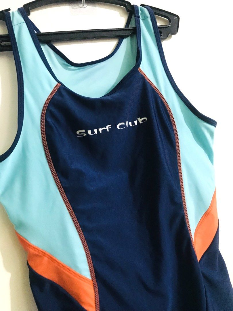 Surf Club Swimsuit (Category: Bikinis & Swimsuits) located in Quezon City. Submitted by mae_iggy (Listing ID 1439848369, Image 2). Description: - Navy blue one-piece swimsuit - Accented with light blue and orange - Features a Surf Club logo - Racerback design with open back - Sleeveless - Round neckline - Short bottoms.