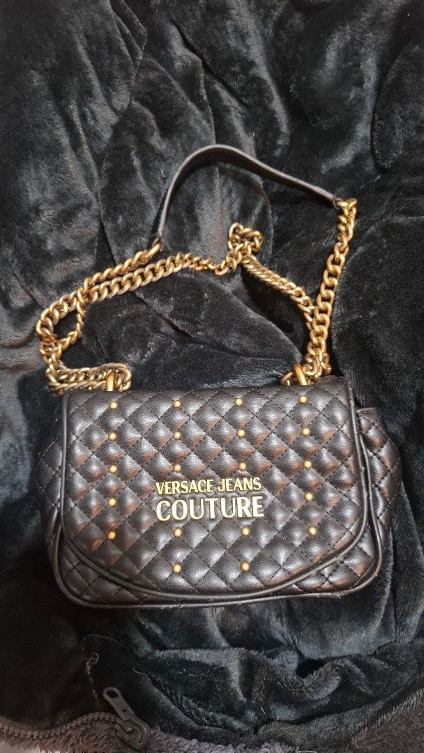 Versace Jeans Couture Quilted Shoulder Bag (Category: Luxury Bags & Wallets) located in Pasay City. Submitted by kgemsluxuryboutique (Listing ID 1439863846, Image 2). Description: - Versace Jeans Couture shoulder bag - Black quilted design - Gold chain strap - Studded detailing - Magnetic closure - Branded interior - Exterior condition: Shows wear on edges and clasp - Interior condition: Clean ORIGINAL po not fake. With etiketa. **Now on sale 100