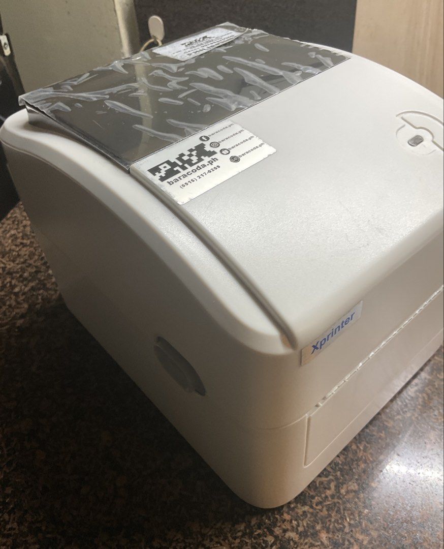 Xprinter Thermal Label Printer with Power Adapter and CD (Category: Printers, Scanners & Copiers) located in Taguig. Submitted by laurenjms (Listing ID 1439992104, Image 3). Description: - Xprinter Thermal Label Printer - Compact and ready for immediate use - Includes original power adapter - Comes with software CD - Starter roll of label paper included - Ideal for various labeling applications.