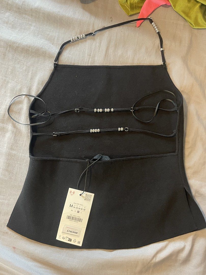 Zara Black Backless Halter Top with Embellished Straps (Category: Sleeveless) located in Mandaluyong City. Submitted by jaed_ (Listing ID 1439894517, Image 2). Description: - Stylish black halter top from Zara - Features a flattering silhouette with a subtle flare - Adorned with sparkling embellishments on halter straps - Adjustable tie-back for a perfect fit - Ideal for night outs or special occasions.