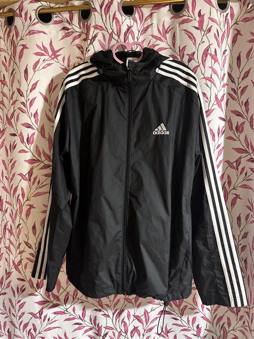 Adidas Black Windbreaker Jacket with White Stripes (Category: Coats, Jackets and Outerwear) located in La Trinidad. Submitted by caicai1926 (Listing ID 1440096687, Image 1). Description: - Classic Adidas windbreaker jacket - Features iconic three stripes on sleeves - Full zip closure - Built-in hood for extra coverage - Ideal for casual wear or light outdoor activities - Made in Cambodia.