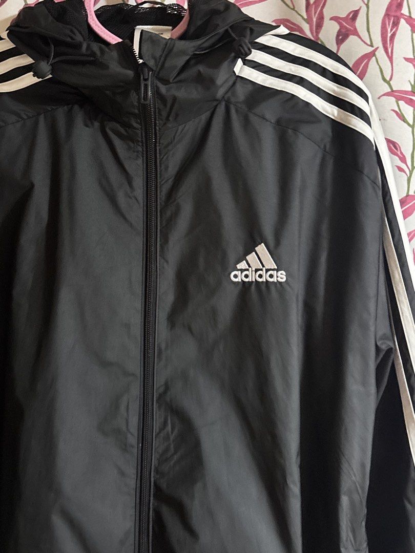 Adidas Black Windbreaker Jacket with White Stripes (Category: Coats, Jackets and Outerwear) located in La Trinidad. Submitted by caicai1926 (Listing ID 1440096687, Image 2). Description: - Classic Adidas windbreaker jacket - Features iconic three stripes on sleeves - Full zip closure - Built-in hood for extra coverage - Ideal for casual wear or light outdoor activities - Made in Cambodia.