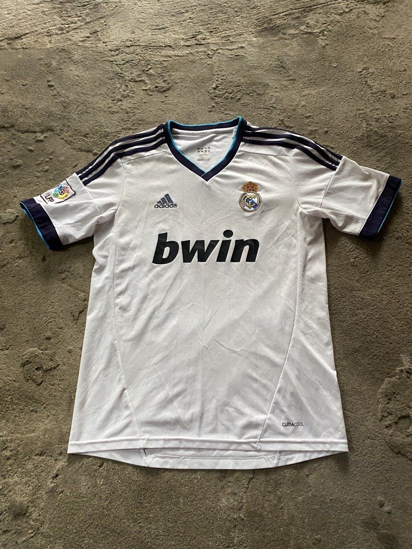 Adidas Real Madrid 2011-2012 Home Jersey Bwin LFP Patch (Category: Activewear) located in Caloocan City. Submitted by remythrift (Listing ID 1440040067, Image 1). Description: - Authentic Adidas Real Madrid home jersey - 2011-2012 season - Features iconic 'bwin' sponsor - Includes LFP patch on sleeve - ClimaCool technology for breathability - Ideal for Real Madrid fans and football collectors.