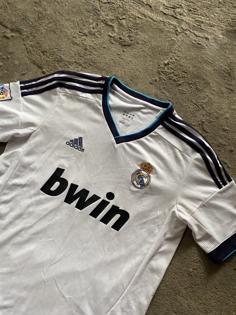 Adidas Real Madrid 2011-2012 Home Jersey Bwin LFP Patch (Category: Activewear) located in Caloocan City. Submitted by remythrift (Listing ID 1440040067, Image 2). Description: - Authentic Adidas Real Madrid home jersey - 2011-2012 season - Features iconic 'bwin' sponsor - Includes LFP patch on sleeve - ClimaCool technology for breathability - Ideal for Real Madrid fans and football collectors.