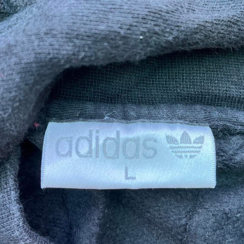 Adidas V-Neck Long Sleeve Sweatshirt (Category: Coats, Jackets and Outerwear) located in Taguig. Submitted by s.showi (Listing ID 1440150136, Image 2). Description: - Classic black Adidas sweatshirt - V-neckline - Iconic white Adidas logo on chest - Contrasting red and white band at the bottom - Perfect for casual wear - Ideal for Adidas collectors.