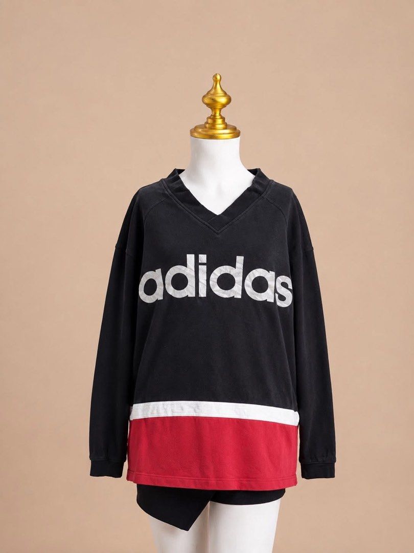 Adidas V-Neck Long Sleeve Sweatshirt (Category: Coats, Jackets and Outerwear) located in Taguig. Submitted by s.showi (Listing ID 1440150136, Image 1). Description: - Classic black Adidas sweatshirt - V-neckline - Iconic white Adidas logo on chest - Contrasting red and white band at the bottom - Perfect for casual wear - Ideal for Adidas collectors.