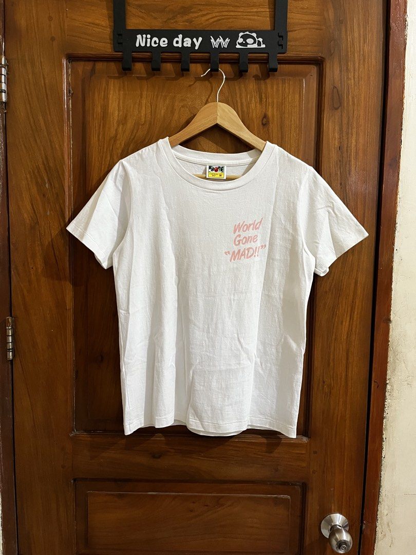 BAPE A Bathing Ape Ladies "World Gone MAD!!" Tee XS (Category: Shirts) located in Bula. Submitted by thrift.wyn (Listing ID 1440031668, Image 1). Description: - Authentic BAPE A Bathing Ape Ladies T-shirt - Color: White - Size: XS - Front Graphic: 'World Gone MAD!!' - Back Graphic: Large ape head with '#93' and 'BAPE' -Yellow stain to be safe washable .