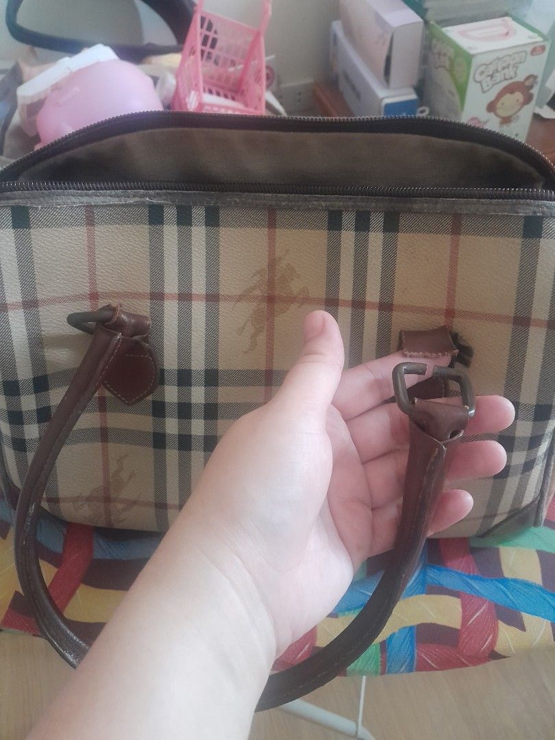 Burberry Nova Check Duffle Bag (Category: Luxury Bags & Wallets) located in Angeles City. Submitted by declutterhub (Listing ID 1440111181, Image 2). Description: - Classic Burberry Nova Check duffel bag - Iconic Burberry plaid pattern - Genuine leather trim and handles - Spacious, lined interior - Secure zipper closure with branded pull - Ideal for travel or everyday use flaw: broken handle. kayo na lang po magpagawa..