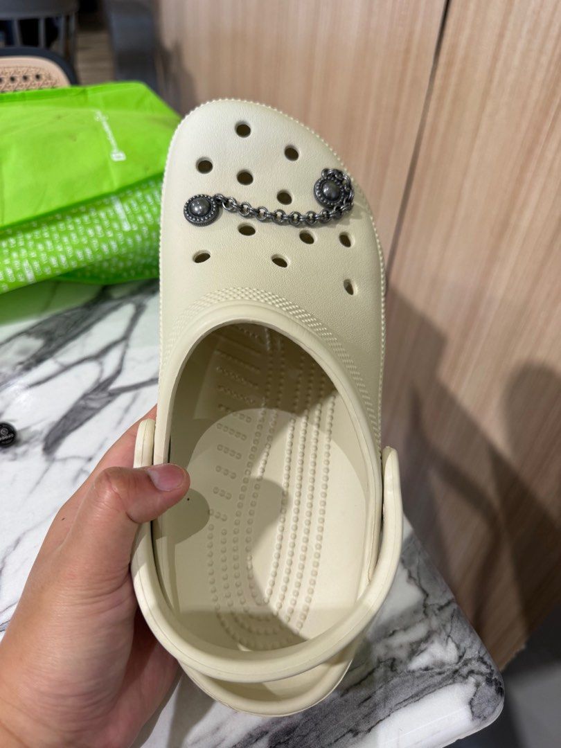 Cream Crocs with Silver Chain and Stud Jibbitz Charms (Category: Other Accessories) located in Cavite. Submitted by yakultjeni85475 (Listing ID 1440170916, Image 2). Description: - Cream-colored Crocs - Unique silver Jibbitz charms included - Features a decorative chain with two stud charms - Made in Indonesia - Perfect for personalized style.