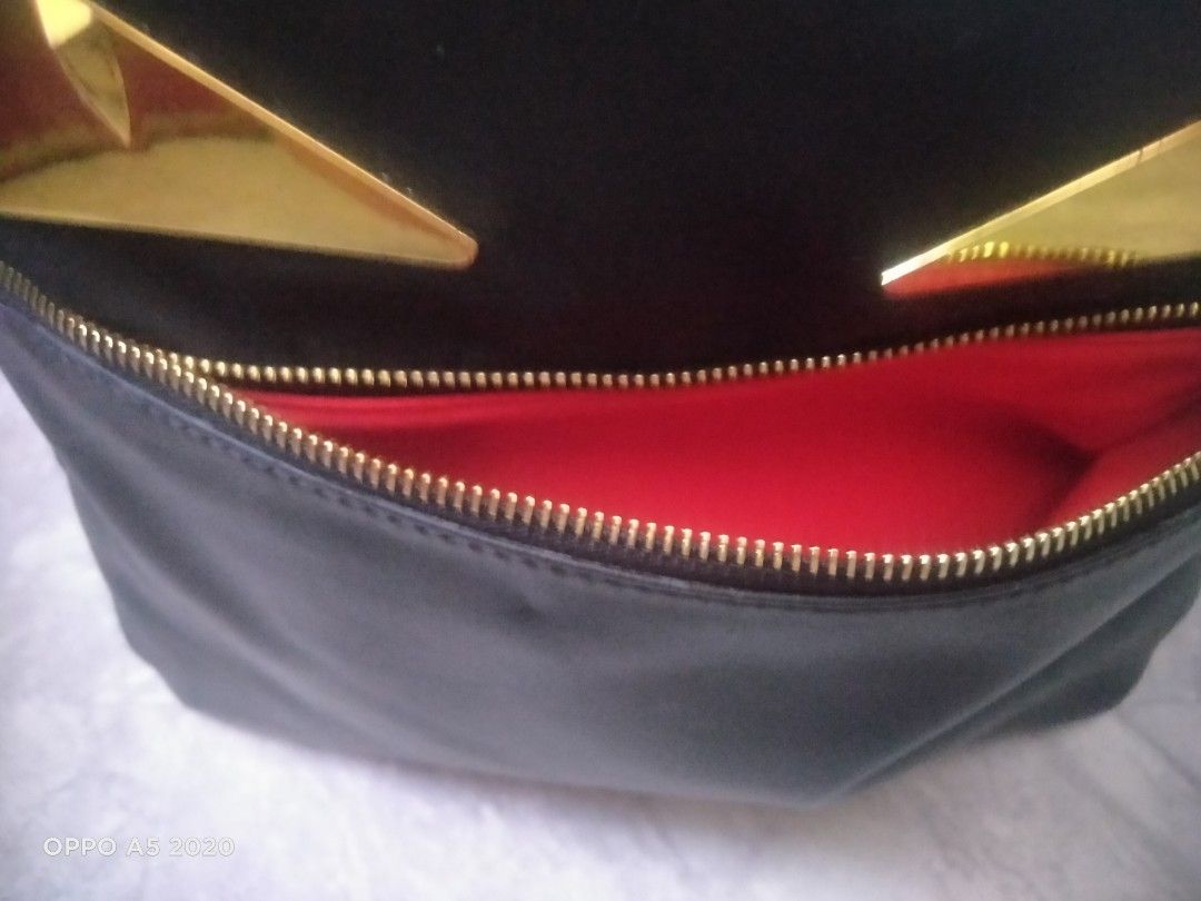Fendi Monster Backpack Black Gold Eyes (Category: Backpacks) located in Manila. Submitted by chanlice0834788 (Listing ID 1440018556, Image 2). Description: - Stylish black Fendi backpack - Iconic gold monster eyes - Spacious main compartment with red interior lining - Front zippered pocket - RFID label for authenticity - Made in Italy.