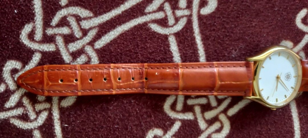 Gold Tone Watch with Brown Leather Strap (Category: Women's Watches) located in Manila. Submitted by fmpc7878 (Listing ID 1440059781, Image 3). Description: - Elegant gold-tone watch - Clean white dial with subtle rose leather strap - Silver buckle - Classic design, suitable for everyday or special occasions - Inscribed text on the back of the watch case GENUINE LEATHER BRACELET NEW BATTERY used, COMMEMORATIVE WATCH.