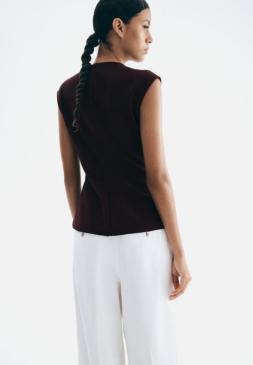 H&M Burgundy V-Neck Sleeveless Vest Top with Gold Buttons (Category: Sleeveless) located in Singapore. Submitted by lltw29 (Listing ID 1440069690, Image 3). Description: - Chic burgundy vest top - Flattering V-neck design - Sleeveless for comfort - Elegant gold button detailing - Modern split hem - Perfect for layering or wearing on its own.