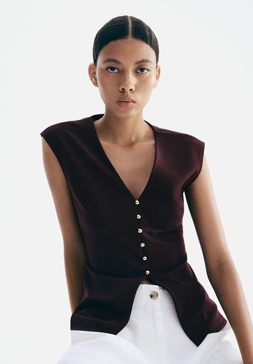 H&M Burgundy V-Neck Sleeveless Vest Top with Gold Buttons (Category: Sleeveless) located in Singapore. Submitted by lltw29 (Listing ID 1440069690, Image 2). Description: - Chic burgundy vest top - Flattering V-neck design - Sleeveless for comfort - Elegant gold button detailing - Modern split hem - Perfect for layering or wearing on its own.