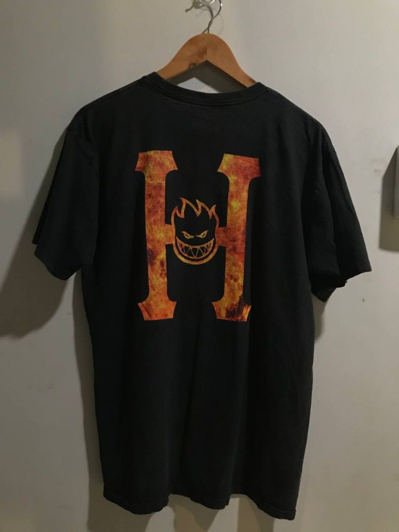 HUf x Spitfire Graphic T-Shirt (Category: Tshirts & Polo Shirts ) located in Manolo Fortich. Submitted by waddupdems (Listing ID 1440028892, Image 3). Description: - Brand: HUF - Color: Black - Size: 20x28 dimes - Front Design: Small HUF logo - Back Design: Large fiery 'H' logo with Spitfire graphic - Style: Graphic T-Shirt, Streetwear.