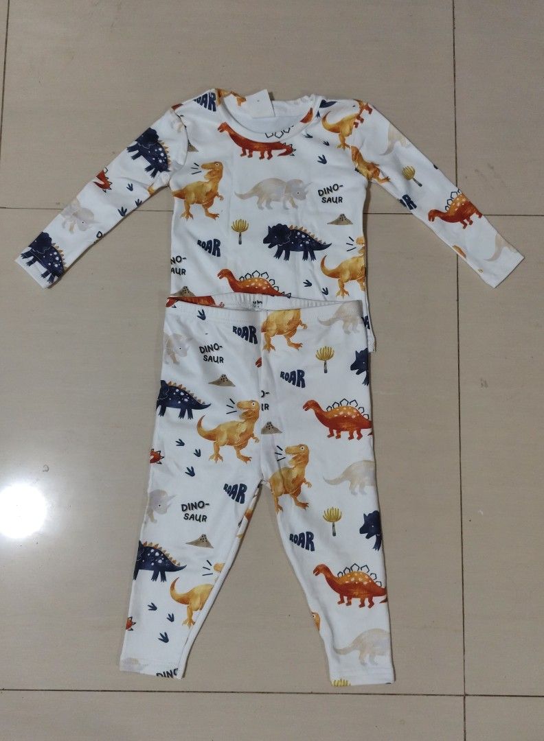 Kids Dinosaur Long Sleeve Pajama Set (Category: Babies & Kids Fashion) located in Pasay City. Submitted by moonbivs (Listing ID 1440043917, Image 1). Description: SHEIN kids - Comfy and cute long-sleeved pajama set for kids. - Features a fun all-over dinosaur print. - Set includes a long-sleeved top and matching pants. - White base with colorful dinosaurs and 'ROAR' text. - Perfect for a good night's sleep..