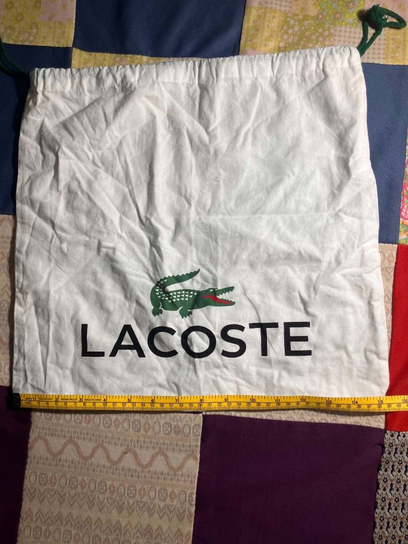 Lacoste Dust Bag (Category: Shoulder Bags) located in Manila. Submitted by ninjadisplay (Listing ID 1440091374, Image 3). Description: ​Brand: Lacoste ​Type: Dual-Cinch Drawstring Protection Dust Bag ​Colorway: Off-White with Signature Green & Black Logo Accents ​Drawstring Color: Forest Green ​📐 Flat Dimensions: ​Width: ~15.5 inches / 39.5 cm ​Height: ~15.5 inches / 39.5 cm.