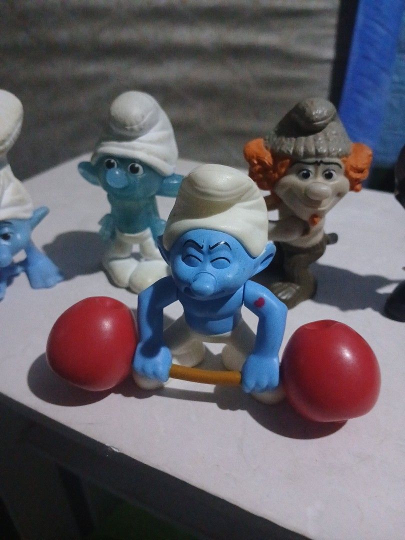Mcdo Smurf happy meal (Category: Figurines & Statues) located in Manila. Submitted by diczenestr94951 (Listing ID 1440099907, Image 3). Description: - Collection of vintage Smurf figurines - Features classic Smurf characters in various poses - Includes Smurfs with white hats and blue bodies - Some figurines are holding red weights - Ideal for collectors and fans of the Smurfs cartoon.