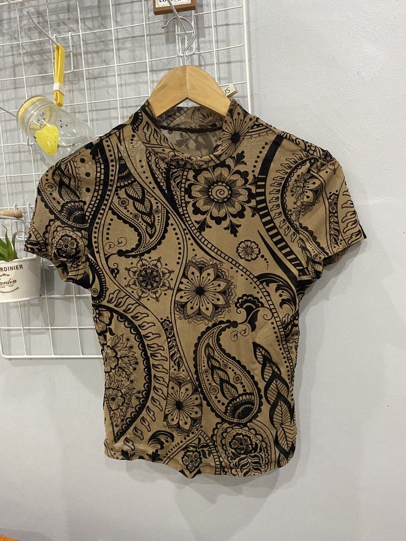 Mesh Mock Neck Top with Paisley Print (Category: Blouses) located in Kalibo. Submitted by bonsaiclo (Listing ID 1440063509, Image 1). Description: - Stylish sheer mesh top - Mock neck and short sleeves - All-over black paisley and floral print on tan background - Perfect for creating a trendy layered look.