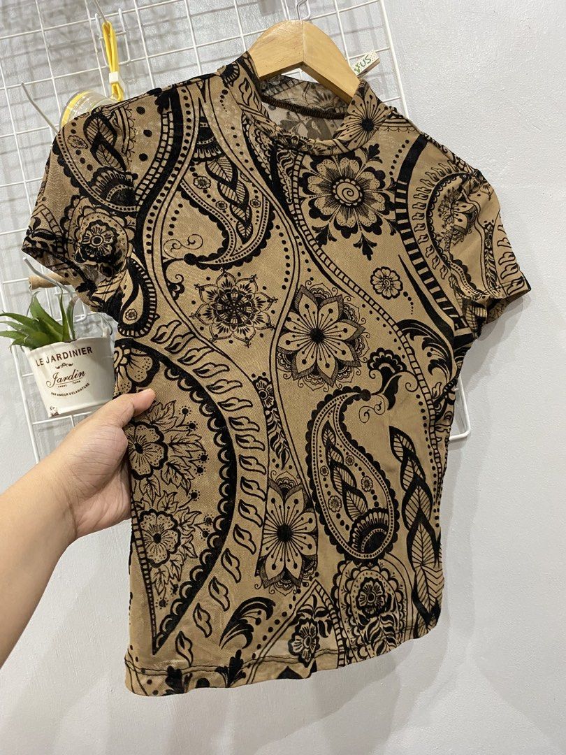 Mesh Mock Neck Top with Paisley Print (Category: Blouses) located in Kalibo. Submitted by bonsaiclo (Listing ID 1440063509, Image 2). Description: - Stylish sheer mesh top - Mock neck and short sleeves - All-over black paisley and floral print on tan background - Perfect for creating a trendy layered look.