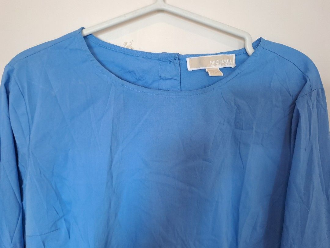 MICHAEL KORS (Category: Blouses) located in Manila. Submitted by joanbalde39643 (Listing ID 1440030955, Image 2). Description: This Michael Kors crew neck top is a cornflower blue long-sleeve blouse made from a lightweight, woven poplin fabric. It features a distinctive button-closure crew neckline at the back and dramatic ruffled cuffs with button closures that give the sleeves a slightly flared, textured finish..