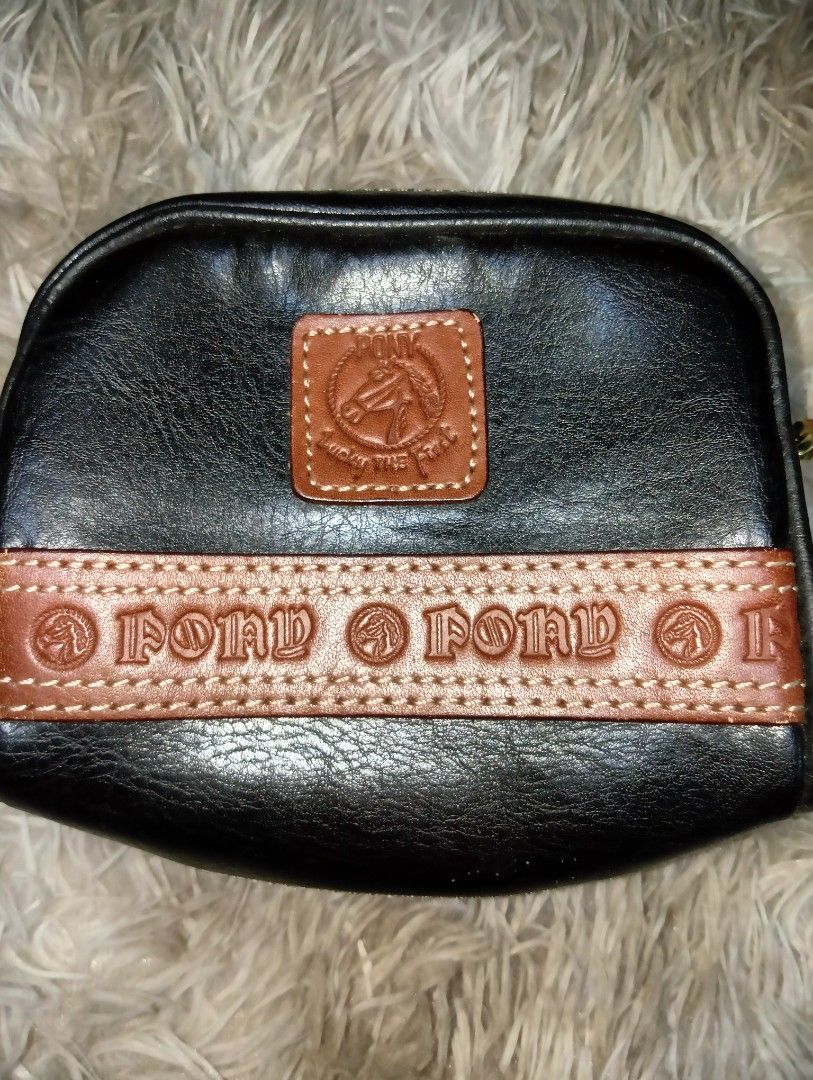 Pond's Black Leather Pouch Bag with Strap (Category: Purses & Pouches) located in Rizal. Submitted by zavrias_closet. (Listing ID 1440078252, Image 1). Description: - Stylish black leather pouch bag from Pony's. - Brown leather accent strap with embossed Pony's logo. - Small brown leather patch with a horse emblem. - Detachable braided strap for shoulder or crossbody wear. - Interior has a small compartment. - Perfect for carrying your essentials