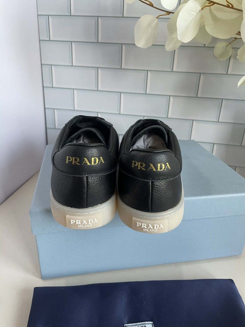 Prada Black Leather Sneakers with Gold Logo (Category: Sneakers) located in Manila. Submitted by rosmiemuno16247 (Listing ID 1440060903, Image 2). Description: - Prada sneakers - Textured black leather - Iconic gold Prada triangle logo on side - 'Prada Milano' branding on heel and sole - Comes with Prada box and dust bag - Perfect for luxury everyday style.