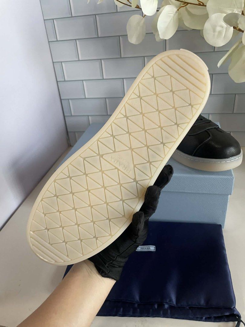 Prada Black Leather Sneakers with Gold Logo (Category: Sneakers) located in Manila. Submitted by rosmiemuno16247 (Listing ID 1440060903, Image 3). Description: - Prada sneakers - Textured black leather - Iconic gold Prada triangle logo on side - 'Prada Milano' branding on heel and sole - Comes with Prada box and dust bag - Perfect for luxury everyday style.