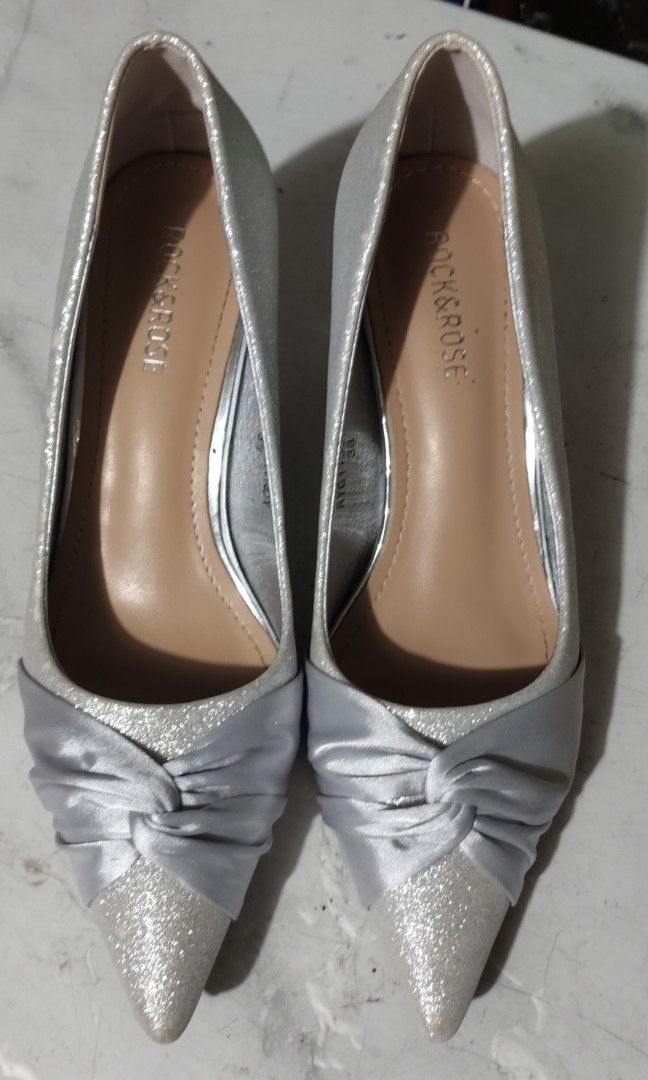 Rock & Rose Silver Glitter Heels with Satin Bow (Category: Heels) located in Quezon City. Submitted by liza.t (Listing ID 1440087979, Image 1). Description: - Brand: Rock & Rose - Color: Silver Glitter - Toe Style: Pointed - Detail: Chic satin bow at the front - Heel Type: Unique block heel - Occasion: Perfect for special occasions or adding sparkle to any outfit -used once.
