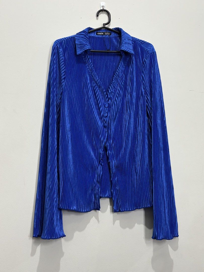 SHEIN Blue Pleated Button-Up Long Sleeve Blouse (Category: Blouses) located in Manila. Submitted by janzelchum82542 (Listing ID 1440175216, Image 2). Description: - Chic blue blouse from SHEIN - Luxurious velvet fabric with all-over pleats - Elegant V-neckline - Button-up front - Long flared sleeves - Adds a touch of glamour to any outfit.