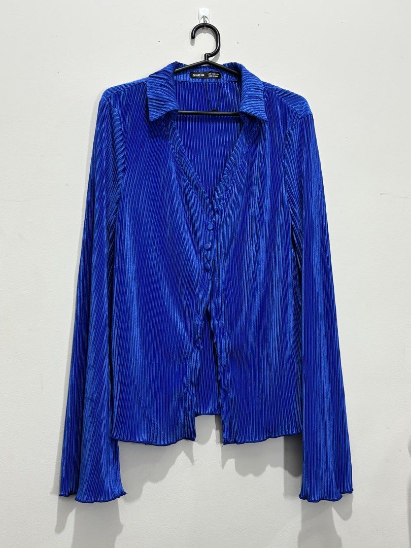 SHEIN Blue Pleated Button-Up Long Sleeve Blouse (Category: Blouses) located in Manila. Submitted by janzelchum82542 (Listing ID 1440175216, Image 1). Description: - Chic blue blouse from SHEIN - Luxurious velvet fabric with all-over pleats - Elegant V-neckline - Button-up front - Long flared sleeves - Adds a touch of glamour to any outfit.