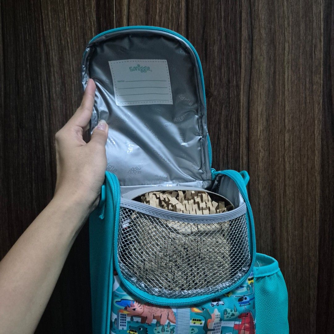 Smiggle Teal Blue Dinosaur Printed Lunch Bag (Category: Other Babies Going Out Needs) located in Manila. Submitted by mho.marie (Listing ID 1440100946, Image 3). Description: Original smiggle (bought in actual smiggle store overseas) Brandnew, never been used insulated lunch bag with sling Can put a lot of items inside if bought with lunch box & sip bottle (please other listings) cab give discount .