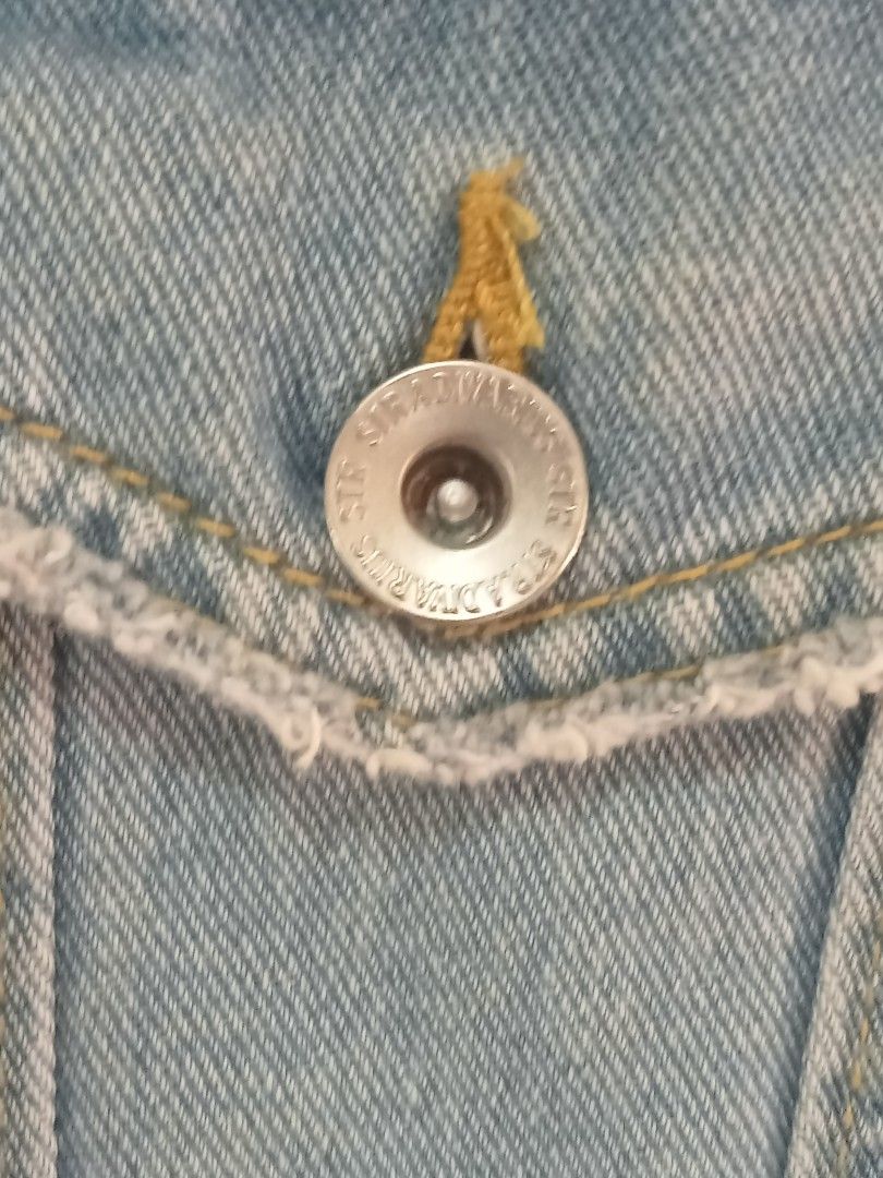 Stradivarius Denim Jacket with Embroidered Back (Category: Coats, Jackets and Outerwear) located in Paete. Submitted by glamluxxereloved (Listing ID 1440031586, Image 3). Description: S on tag but can fit Medium Pre-loved not ukay - Stradivarius light wash denim jacket - Distressed details on sleeves - Unique embroidered tribal-inspired design on back - Classic button-up front - Chest pockets - Adds a stylish edge to any outfit Vguc needs wash ka