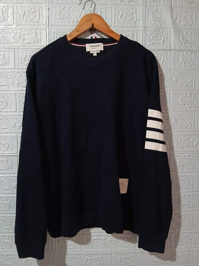 Thom Browne Navy Sweatshirt with White Stripes (Category: Luxury Apparel) located in Davao. Submitted by noelamihan05424 (Listing ID 1440085470, Image 1). Description: - Classic navy sweatshirt from Thom Browne - Features signature white stripes on the sleeve - Small woven label detail - Made in Italy - Perfect for a stylish casual look - Size 4 Large to XL fit - Dimes 22x27 - Color rate 9.5/10 - No issue .