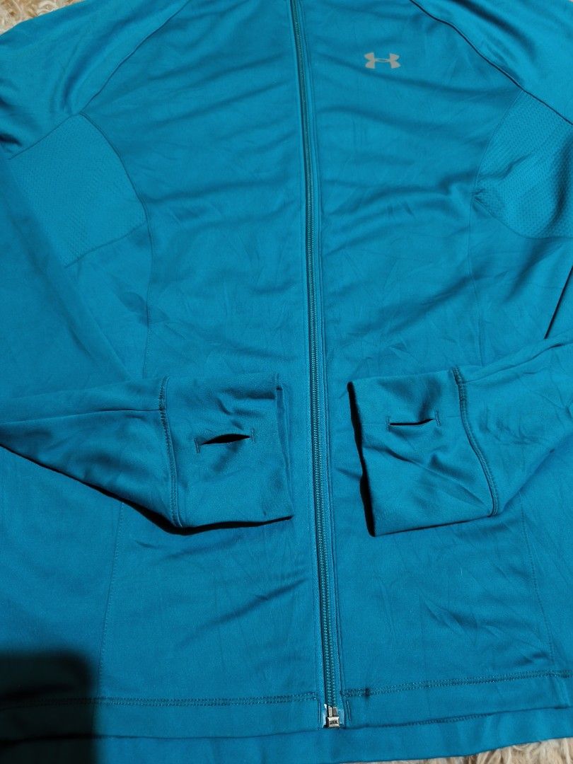 Under Armour Teal Zip-Up Jacket with Thumbholes (Category: Coats, Jackets and Outerwear) located in La Paz. Submitted by carou89146 (Listing ID 1440072498, Image 2). Description: - Under Armour teal zip-up jacket - Features convenient thumbholes - Lightweight fabric - Ideal for workouts or casual wear - Versatile addition to your active wardrobe pit to pit 22 inches length 27 inches spandex needs washing excellent condition .