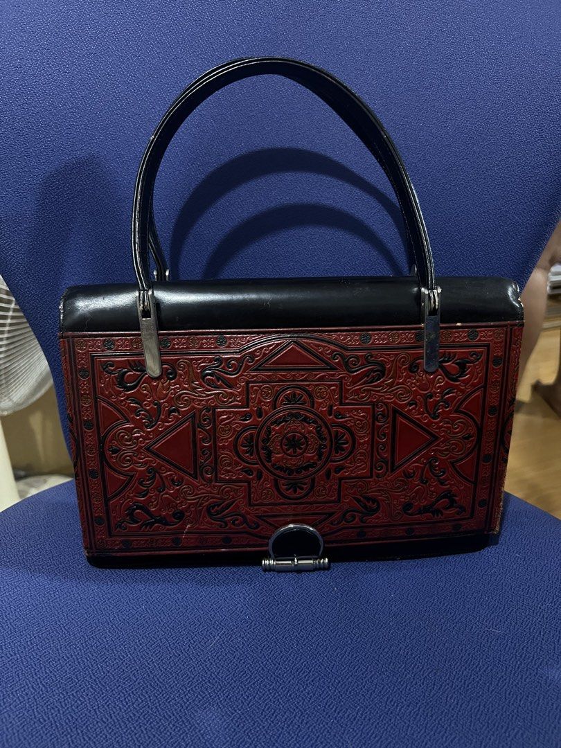 Vintage Embossed Red and Black Handbag (Category: Clutches) located in Manila. Submitted by kim.caren (Listing ID 1440079024, Image 1). Description: - Elegant vintage black handbag - Intricate embossed detailing on the front - Classic black top handle - Spacious interior with zippered pocket and slip pocket - Perfect for a touch of retro charm.
