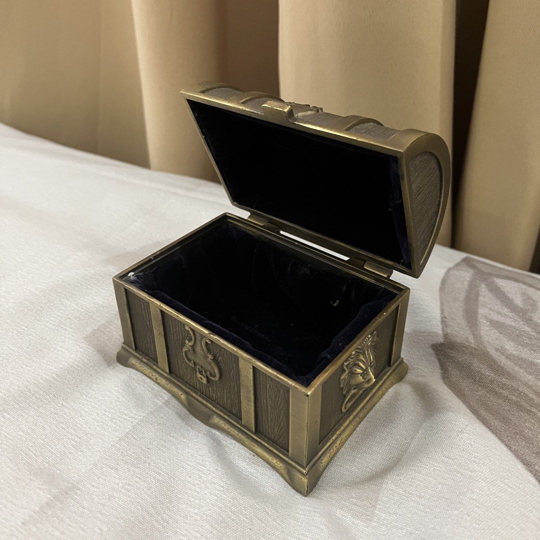 Vintage Style Treasure Chest Trinket Box (Category: Storage Boxes & Baskets) located in Manila. Submitted by princess.01.1 (Listing ID 1440021748, Image 3). Description: - Charming vintage-style treasure chest box - Ideal for storing small valuables or as a decorative piece - Intricate detailing reminiscent of old pirate chests - Metallic bronze finish - Plush black interior lining - Spacious compartment when lid is opened.