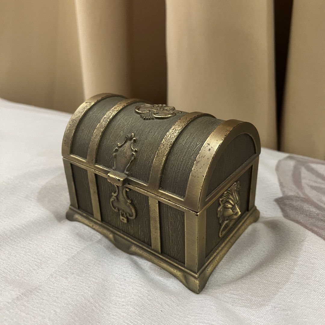 Vintage Style Treasure Chest Trinket Box (Category: Storage Boxes & Baskets) located in Manila. Submitted by princess.01.1 (Listing ID 1440021748, Image 2). Description: - Charming vintage-style treasure chest box - Ideal for storing small valuables or as a decorative piece - Intricate detailing reminiscent of old pirate chests - Metallic bronze finish - Plush black interior lining - Spacious compartment when lid is opened.