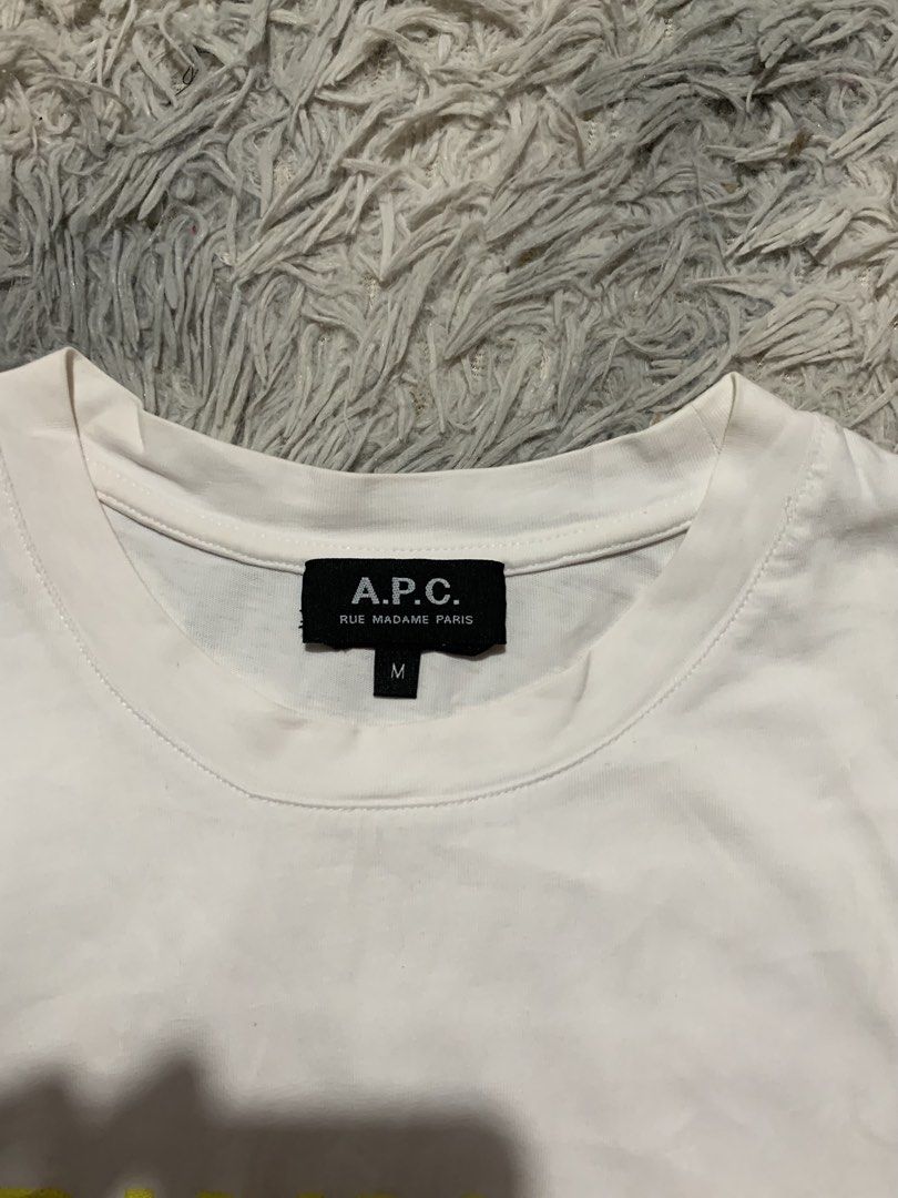 A.P.C. "Radically Minimal" T-Shirt Size M (Category: Tshirts & Polo Shirts ) located in Cebu City. Submitted by ninyothrift (Listing ID 1440344877, Image 3). Description: - Brand: A.P.C. - Color: White - Size: M - Design: Crew neck, short sleeves - Embroidery: 'RADICALLY MINIMAL' in yellow on the chest - Logo: Subtle A.P.C. logo embroidered on the sleeve - Origin: Made in Portugal - Style: Classic, minimalist staple piece - 21x27 - Excellent cond