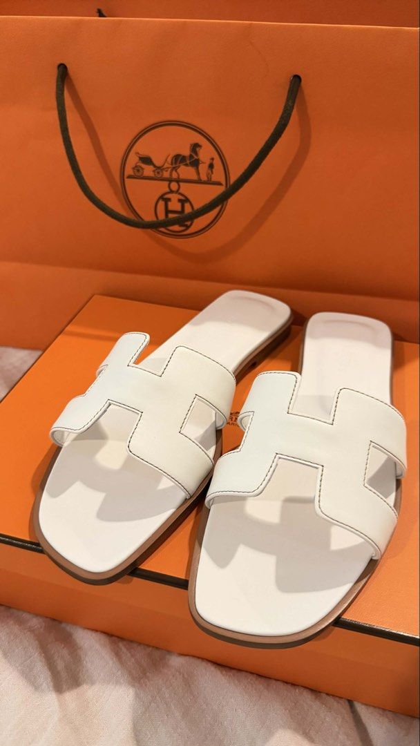 Authentic Hermes Oran Sandals in White size 38.5 (Category: Flats & Sandals) located in Paranaque City. Submitted by coffeebeanss (Listing ID 1440274649, Image 2). Description: authentic Hermes Oran Sandals in White 🤍 - size 38.5 - purchased in Osaka last year, never worn - selling these much lower than SRP - rfs: impulse purchase, already have this style in other colors - comes with individual shoe bags, box, paper bag.