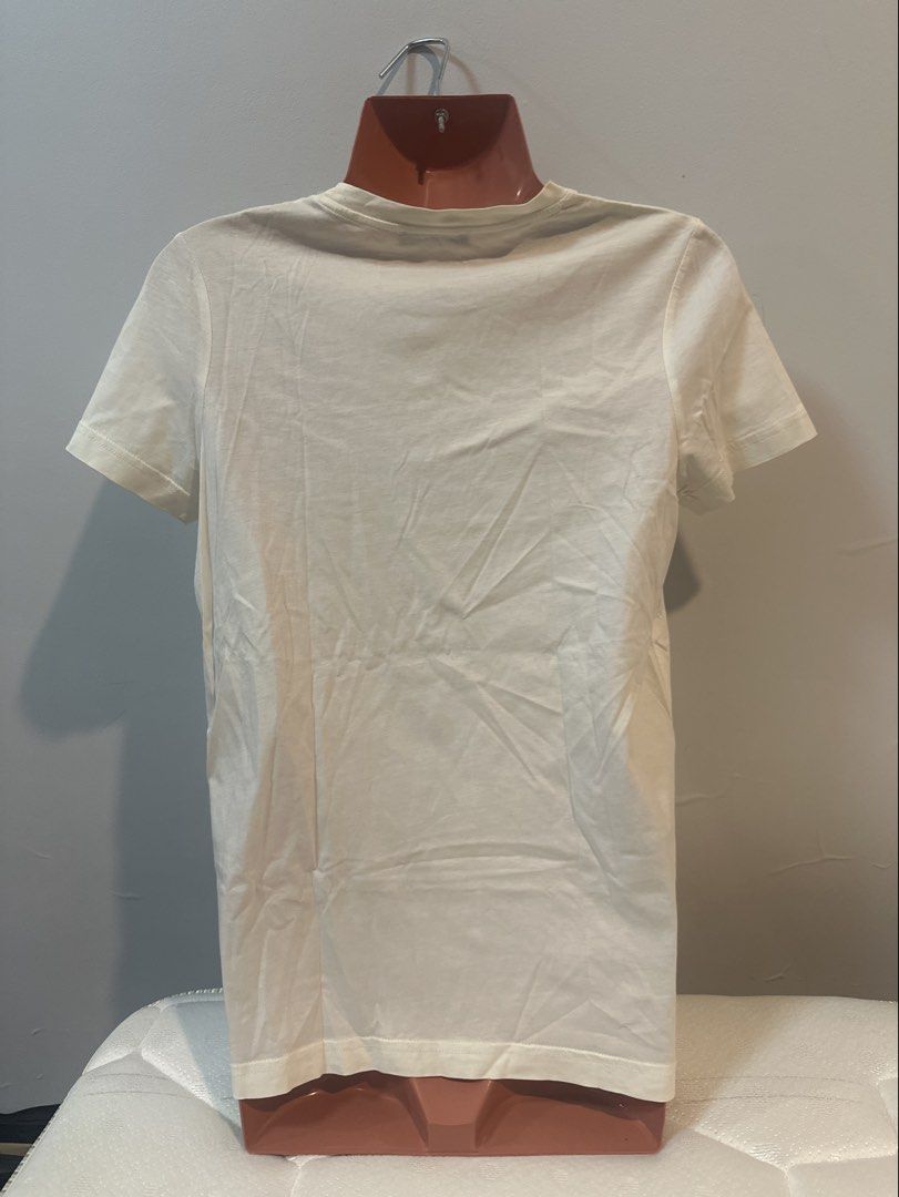 Balmain Paris White T-shirt (Category: Shirts) located in Las Pinas. Submitted by Mkdot (Listing ID 1439832044, Image 2). Description: - Balmain Paris T-shirt - White with gold print - Crew neck - Short sleeves - Decorative gold buttons on shoulder - Plain white back - Lightweight fabric.