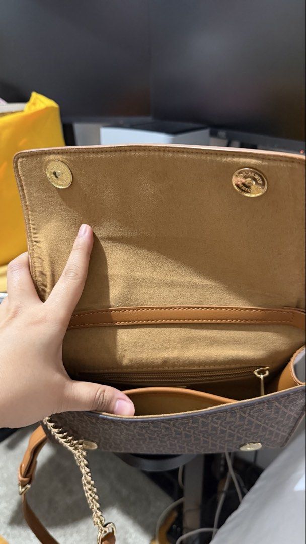 Brown Monogram Clutch Bag with Gold Chain Strap (Category: Clutches) located in Manila. Submitted by wisewind_6fa49c (Listing ID 1440236100, Image 2). Description: - Stylish brown clutch bag - Repeating monogram pattern - Gold-tone logo emblem - Secure snap closure - Spacious interior with zippered pocket - Detachable gold chain and leather strap - Versatile carrying options - Perfect for evenings out or adding elegance.