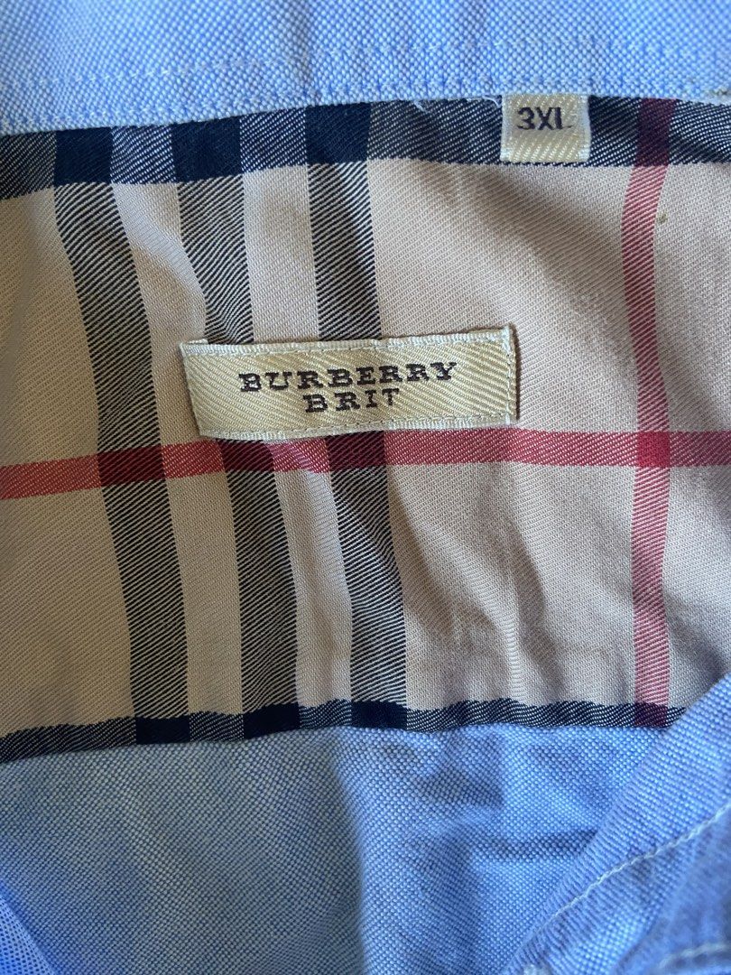 Burberry Brit Men's Blue Button Down Shirt 3XL (Category: Tshirts & Polo Shirts ) located in Tuguegarao City. Submitted by nero_28 (Listing ID 1440366639, Image 3). Description: - Blue Burberry Brit button-down shirt - Size: 3XL - Classic Burberry check lining inside collar and placket - Small embroidered Burberry logo on chest - Versatile for casual or smart-casual occasions.