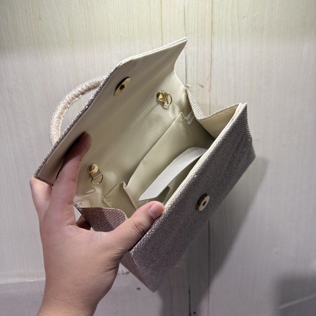 Champagne Classy Sling Bag with Handle (Category: Clutches) located in Tarlac. Submitted by milkshakeee_ (Listing ID 1440276041, Image 3). Description: - Never been used (BRAND NEW) - Bought at tiktok - Champagne sparkly clutch bag - Convenient short handle - Secure magnetic snap closure - Includes a small inner pocket - Ideal for parties, events, and special occasions - Fits essentials like your phone, keys, and lipstick.