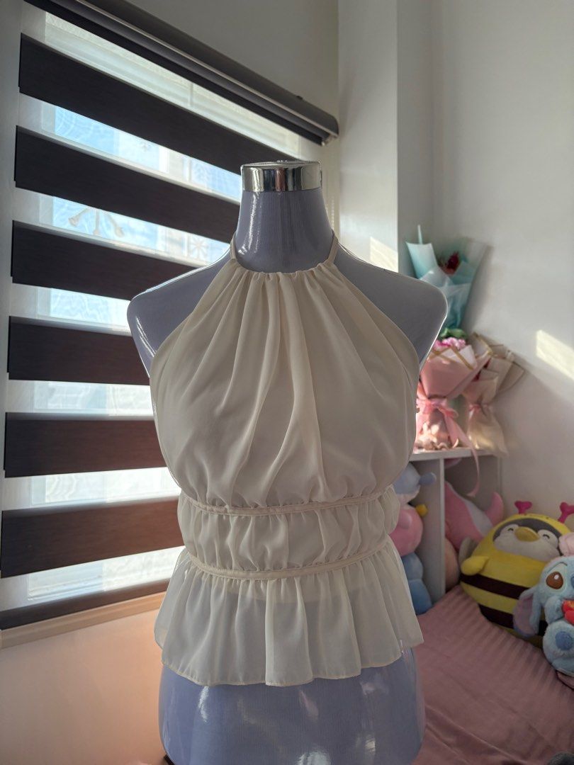 Cream Halter Backless Waist Peplum Top (Category: Sleeveless) located in Angeles City. Submitted by jeonsaceee (Listing ID 1440247104, Image 1). Description: - Size: S-M - Cream halter neck top - Backless - Lightweight and flowy fabric - Ties at the neck for adjustable fit MOP: Gcash MOD: Jnt No cancellation/No return DM if interested💌!.